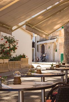 Tables et chaises de restaurant méditerranéen dans la rue sur Alex Winter
