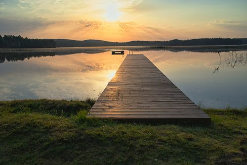 Loopbrug, naar de zonsopgang, reikend in een Zweeds meer