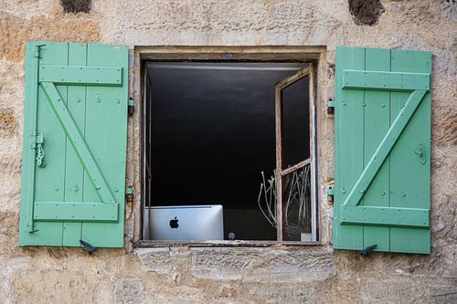 Apple iMac achter een raam met groene luiken