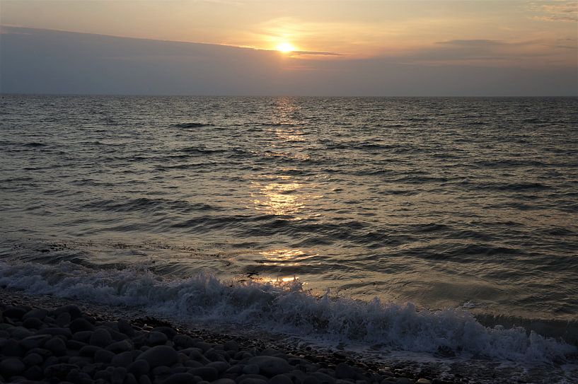 Beautiful sunset on a pebble beach in Brittany France by Sandra van der Burg