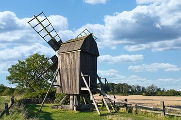 Vieux moulin à vent en bois dans un paysage idyllique sous un ciel bleu