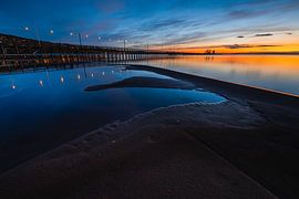 Beleuchteter Holzsteg bei Sonnenuntergang von Martijn Smeets