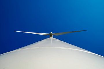Kikvorsperspectief van propeller van windturbine tegen strak blauwe lucht. van Sven Van Santvliet