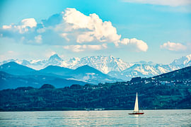 Sailing boat on Lake Constance and the Swiss Alps covered in snow by Dieter Walther