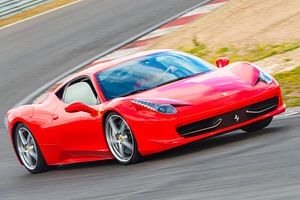Roter Sportwagen Ferrari 458 Italia fährt auf einer Rennstrecke
