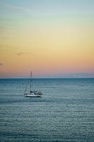 Schwimmendes Segelboot bei Sonnenuntergang