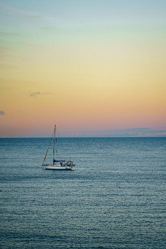 Floating sailboat during sunset