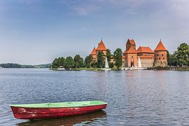 Trakai castle and a small boat in the Galve lake by Marc Venema