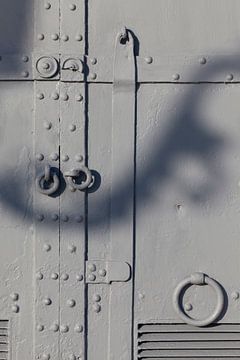 Reisfotografie. Oude, grijze deuren met schaduw van straatlantaarn