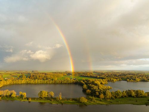 Regenboog tijdens een herfstbui boven de IJssel