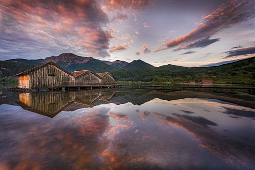 Drie boothuizen met aanlegsteiger aan de Kochelsee in de Beierse uitlopers van de Alpen