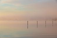 mistige zonsopkomst over het water met reflectecerende palen en pastel van Kim Willems thumbnail