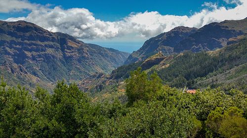 Two green covered mountain ridges on Madeira with sea and clouds in the background