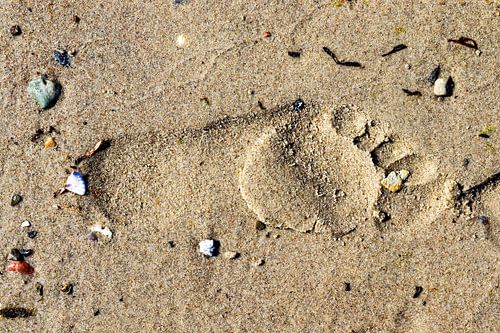 Enkele voetafdruk in het zand op het strand van de Oostzee