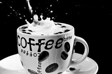 Vallende koffiebonen in een koffie tas met melk von Geert D
