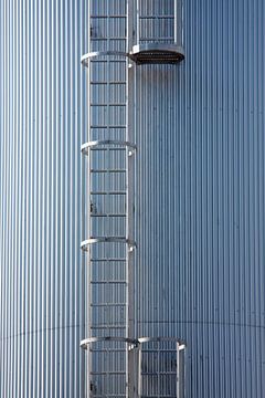 Silver blue silo with steel ladder by Jan Brons