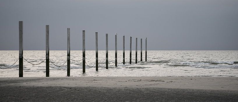Verwitterte Masten an der Strandpromenade von Rik Verslype