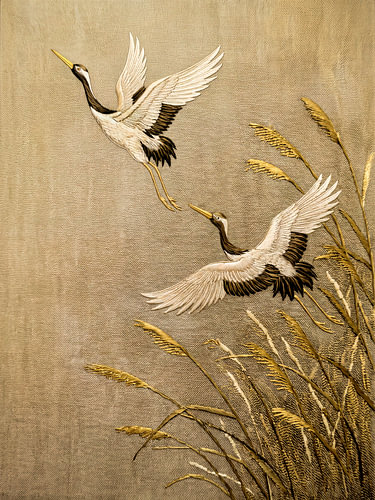 Traditional Asian Art: Cranes flying above the reeds in shades of gold