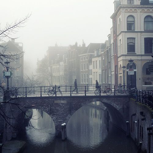 Pedestrians on the Maartensbrug in a foggy Utrecht