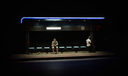 Frau wartet an einer Bushaltestelle in Bangkok von Bart van Lier