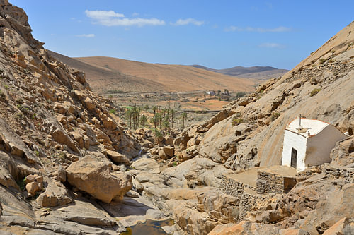 Petite chapelle blanche « Ermita de La Peña », située dans un canyon désertique rocheux parsemé de palmiers