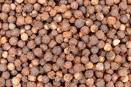 Black peppercorns creating spice food ingredient background texture