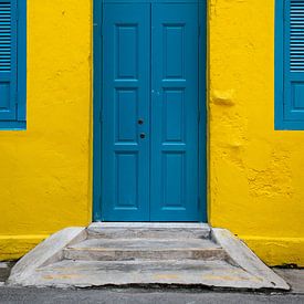 Mur jaune avec une porte bleue à Kuala Lumpur sur Bas Potman