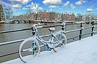 Besneeuwde fiets aan de Amstel in Amsterdam in de winter van Eye on You thumbnail