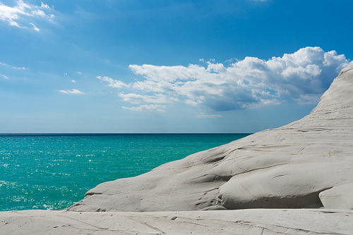 Glooiende witte klif aan turquoise zee