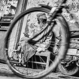 Man with turban framed by bicycle wheel by Leonie Broekstra
