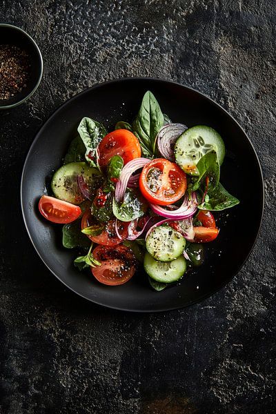 Frischer Salatmix auf schwarzem Teller von Poster Art Shop