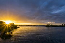 USA, Florida, Goldener Sonnenuntergang mit schönen Reflektionen auf dem Wasser und der Brücke und den Häusern dahinter von adventure-photos