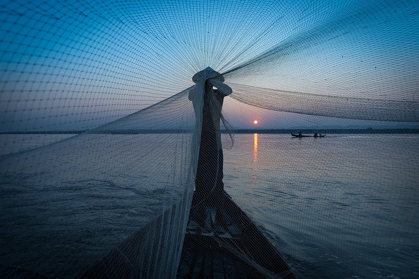 Ein Fischer faltet seine Netze auf der Straße nach Mandelay in Myanmar. Wout Kok One2expose Fotograf von Wout Kok