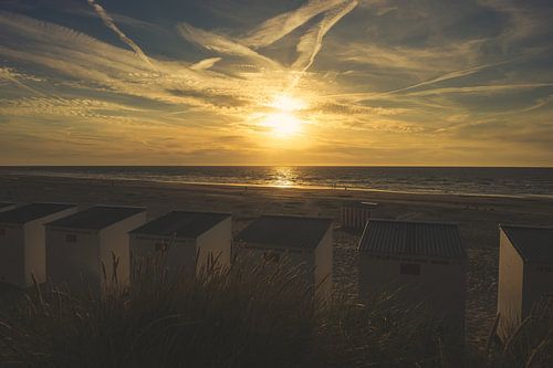 Zonsondergang op het strand met strandcabines