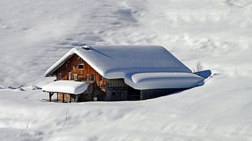 Diep besneeuwde alpenhut op een zonnige winterdag van chamois huntress