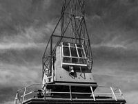 Industriële hijskraan met dramatische lucht in zwart-wit