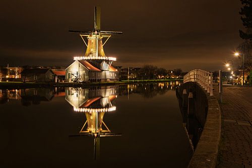 Beleuchtete Mühle mit Spiegelung im Wasser in den Niederlanden von iPics Photography