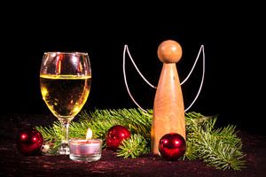 Houten engeltjes en wijnglas met kerstversiering versierd met dennenbomen en kerstballen. van Hans-Jürgen Janda