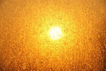 The sun shining through a window with droplets on it