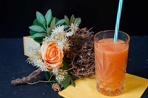 Sinaasappel papaya banaan smoothie in een glas.