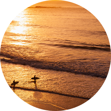Surfers bij zonsondergang op strand in de Algarve, Portugal van Chris Heijmans