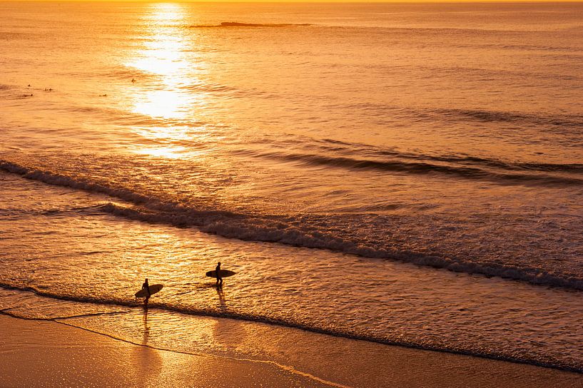 Surfers bij zonsondergang op strand in de Algarve, Portugal van Chris Heijmans