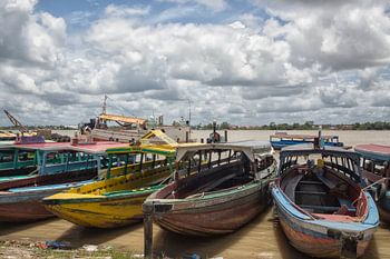 Kleurrijke traditionele houten motorboten in Paramaribo aan de rand van de rivier.
