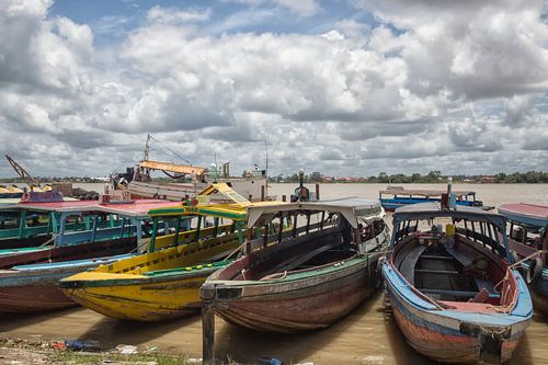 Kleurrijke traditionele houten motorboten in Paramaribo aan de rand van de rivier.