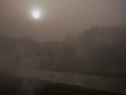 Sunlight over a dark, misty landscape