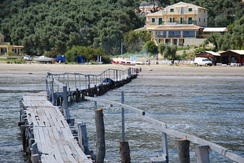 Een houtensteiger in de zee aan de kust van Corfu. 