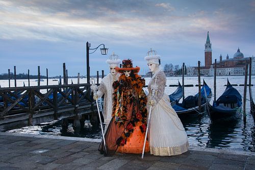 Karneval in Venedig 3 Modelle posieren neben den Gondeln.