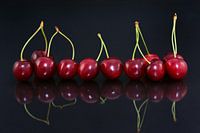 Red cherries are reflected on the table