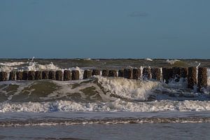 Eine Welle überschlägt sich an den Wellenbrechern an der Küste von Zeeland