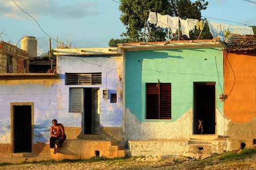 Eine typisch kubanische Straßenszene mit bunten Häusern und Kopfsteinpflastern
